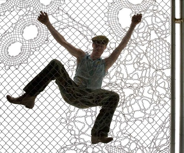 Man Climbing Lace Fence